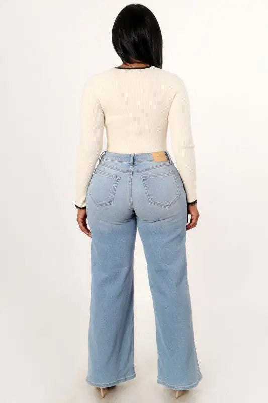Back view of women’s high rise asymmetrical waist wide leg jeans in classic denim