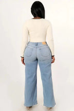 Back view of women’s high rise asymmetrical waist wide leg jeans in classic denim