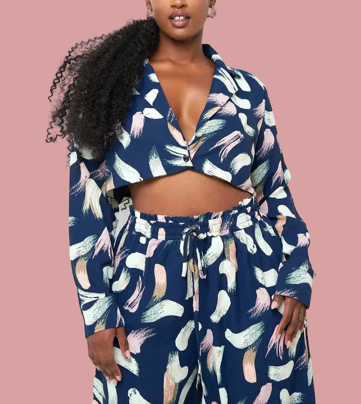 Close-up of plus size model wearing navy abstract print plunge crop top with deep V-neckline and one-button front