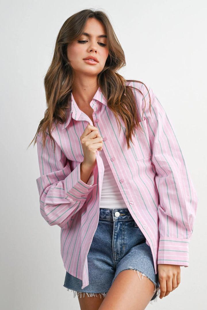 Woman wearing a pink striped shirt and denim shorts 