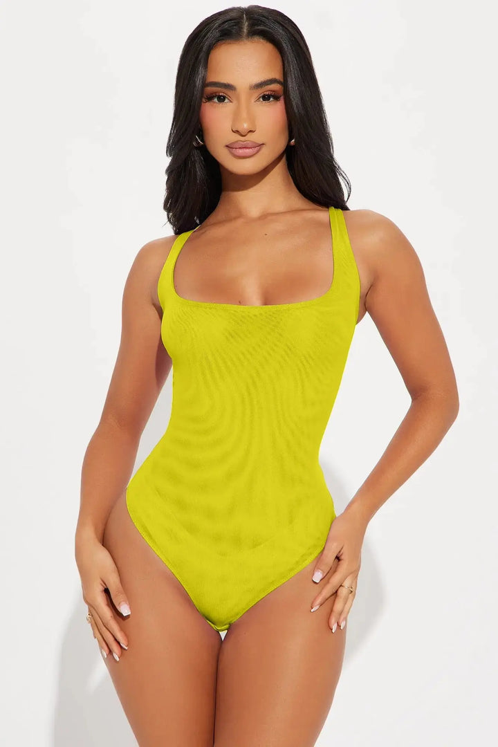 Front view of lime green mesh bodysuit with square neckline and corset seaming on model on white background