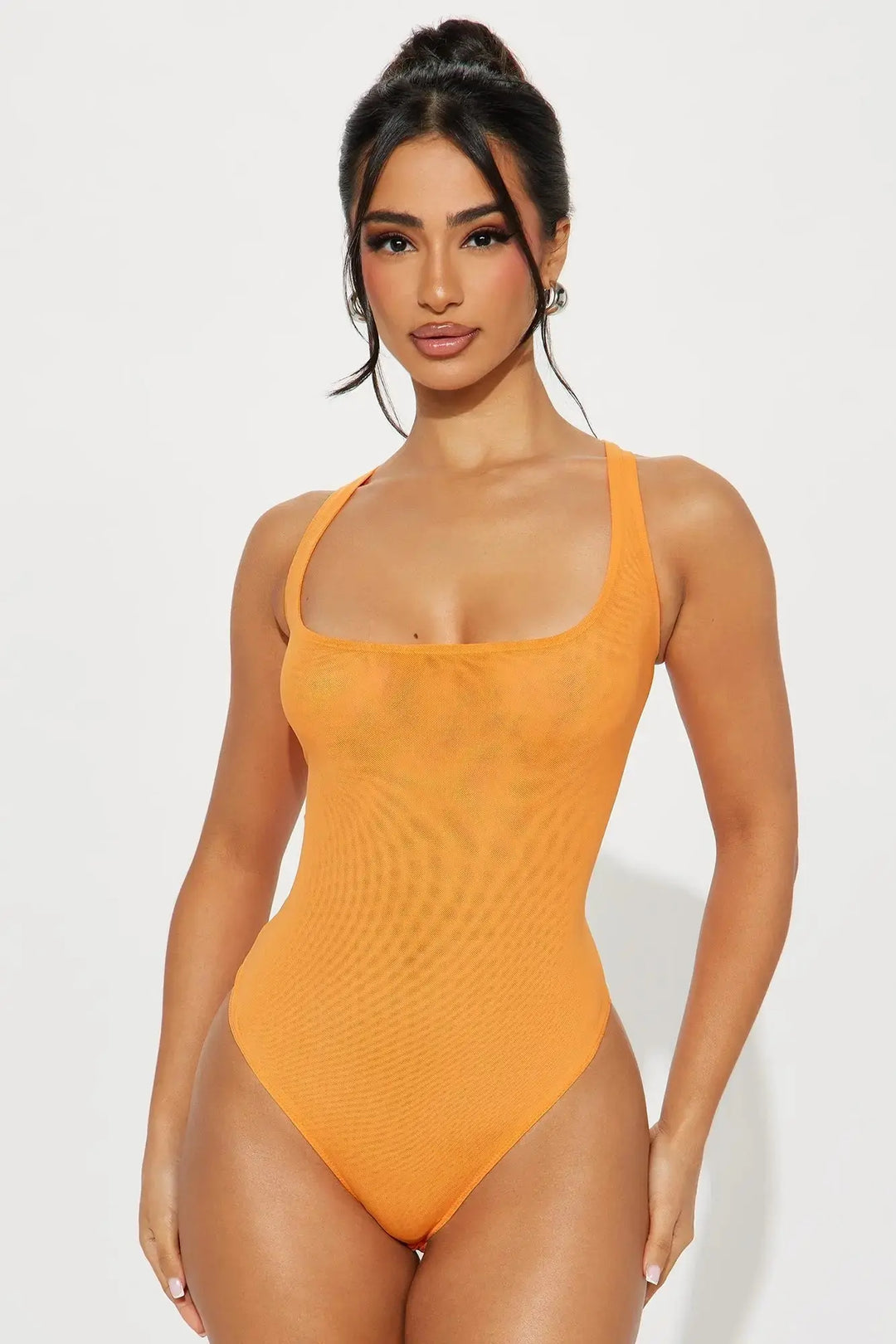 orange mesh thong bodysuit showing thong cut and corset seaming on model on white background