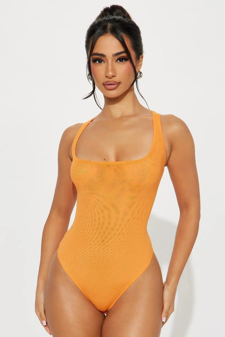 orange mesh thong bodysuit showing thong cut and corset seaming on model on white background