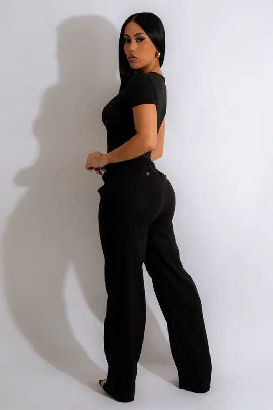 Woman wearing black linen wide leg trousers front view with black top and heels